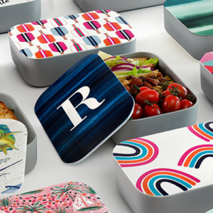 A collection of lunch boxes featuring diverse designs, showcasing vibrant colors and unique patterns.