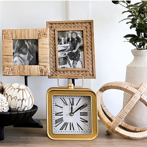 A clock, picture frame, and vase elegantly arranged on a wooden shelf, showcasing a harmonious home decor.